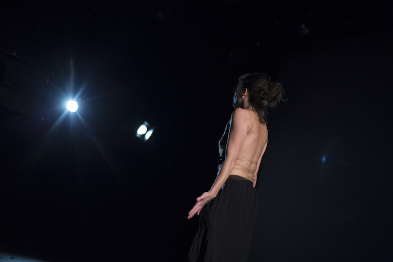 Rebeca Medina in a filmy top stars at a bright light that resembles a star amongst a dark sky